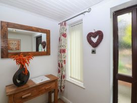 A hallway with a mirror and a console table at Gwylan Uchaf Y Felinheli