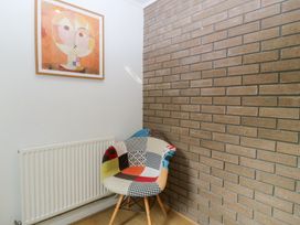A corner with a patterned chair, radiator, and artwork at Gwylan Uchaf in Y Felinheli