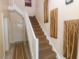 A staircase and hallway with wall art at Gwylan Uchaf in Y Felinheli