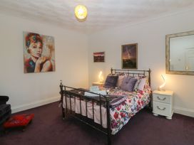 A bedroom with a bed and paintings at Gwylan Uchaf in Y Felinheli