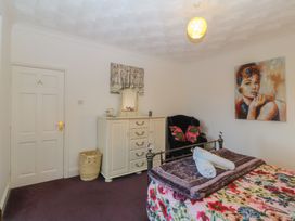 A bedroom with a bed and dressing table at Gwylan Uchaf Y Felinheli