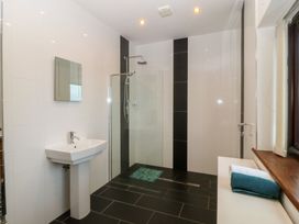 A bathroom with sink, shower, and towel at Gwylan Uchaf Y Felinheli