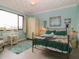 A bedroom with a bed and wardrobe at Gwylan Uchaf Y Felinheli