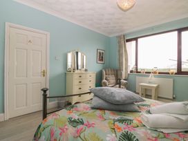 A bedroom with a bed and dresser at Gwylan Uchaf Y Felinheli