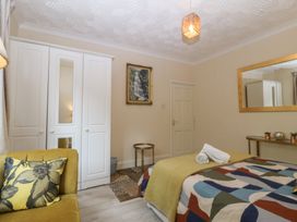 A bedroom with a bed and wardrobe at Gwylan Uchaf in Y Felinheli