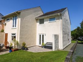 An outdoor area of a house with patio, door and windows at Machlud Ynys in Y Felinheli
