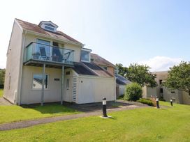 A house with a balcony and surrounding greenery at Machlud Ynys Y Felinheli