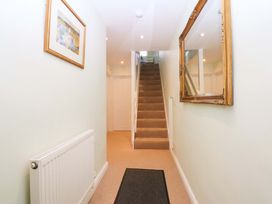 A hallway with a staircase and mirror at Machlud Ynys in Y Felinheli