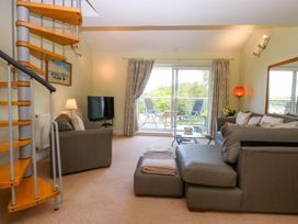 A living room with a staircase and a TV at Machlud Ynys, Y Felinheli