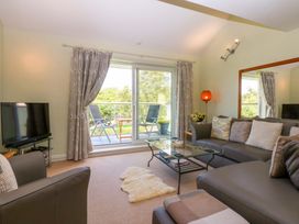 A living room with a sofa and television at Machlud Ynys in Y Felinheli