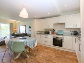 A kitchen with a table and chairs at Machlud Ynys, Y Felinheli