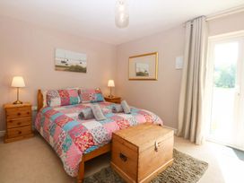 A bedroom with a bed and nightstands at Machlud Ynys in Y Felinheli