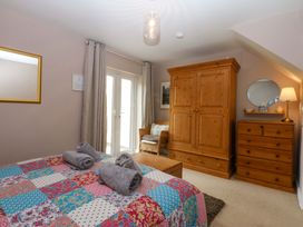 A bedroom with a bed and wardrobe at Machlud Ynys Y Felinheli