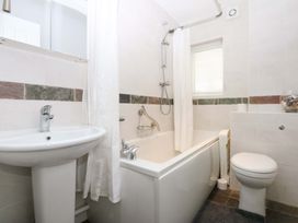 A bathroom with a bathtub, sink, and toilet at Machlud Ynys, Y Felinheli
