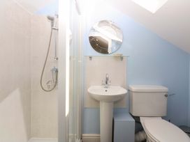 A bathroom with a shower, sink, and toilet at Machlud Ynys, Y Felinheli