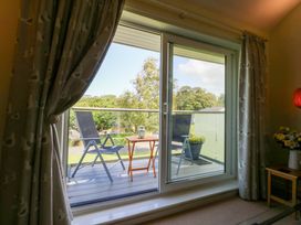 A living room with a sliding door leading to a balcony at Machlud Ynys, Y Felinheli
