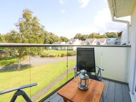 A balcony with a chair and table at Machlud Ynys Y Felinheli