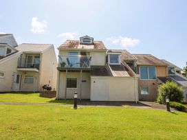 A house with a balcony and grass area at Machlud Ynys in Y Felinheli