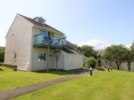 A house with a balcony and grass area at Machlud Ynys in Y Felinheli