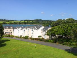 A view of houses with grass and trees at Machlud Ynys Y Felinheli