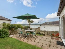 A garden with a table and chairs at Menai Cottage in Brynsiencyn