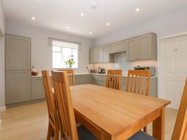A kitchen with a dining table and chairs at Menai Cottage in Brynsiencyn