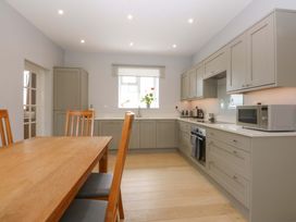 A kitchen with a table and chairs at Menai Cottage in Brynsiencyn