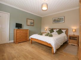 A bedroom with a bed and dresser at Menai Cottage in Brynsiencyn