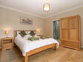 A bedroom with a bed and wardrobe at Menai Cottage in Brynsiencyn