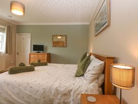 A bedroom with a bed and a television at Menai Cottage in Brynsiencyn