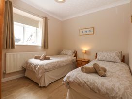 A bedroom with two single beds at Menai Cottage in Brynsiencyn