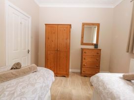 A bedroom with a wardrobe and mirror at Menai Cottage in Brynsiencyn