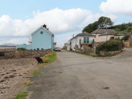 A coastal scene with a house and road at Menai Cottage Brynsiencyn