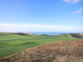 A landscape view featuring grass fields and a sea at Pen y Bont Bach in Red Wharf Bay