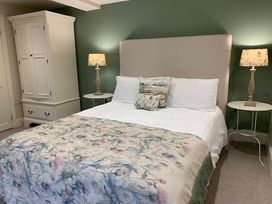 A bedroom with a bed and a wardrobe at The Honey Pot in Garndolbenmaen