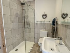 A bathroom with a shower, toilet and sink at Tri Raglan Mawr Beaumaris