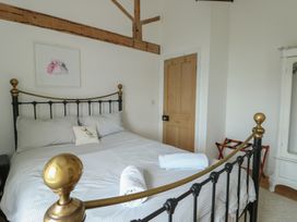 A bedroom with a bed and a door at Tri Raglan Mawr in Beaumaris