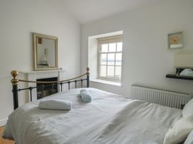 A bedroom with a bed and window at Tri Raglan Mawr Beaumaris