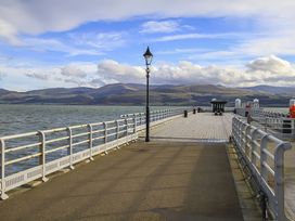 A pier with a lamppost and railing at Tri Raglan Mawr in Beaumaris