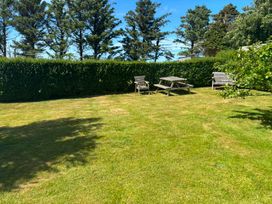 A garden with grass, a table, and chairs at Ty Bryn - Nefyn in Morfa Nefyn