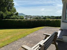 A garden with a bench and scenic view at Ty Bryn - Nefyn, Morfa Nefyn