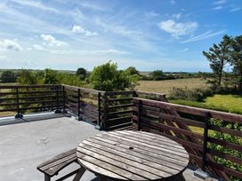 An outdoor space with a wooden table and a view at Ty Bryn - Nefyn Morfa Nefyn