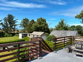 A view of a deck with trees and sheds at Ty Bryn - Nefyn Morfa Nefyn