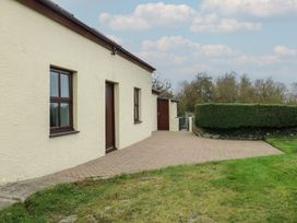 An exterior view of a house with pathways and greenery at Tyn y Mynydd in Bull Bay