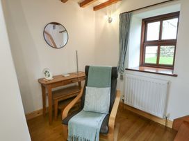A snug with a chair and a table at Tyn y Mynydd in Bull Bay