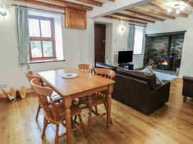 A dining room with a table and chairs at Tyn y Mynydd in Bull Bay
