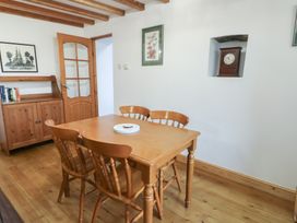 A dining room with a wooden table and chairs at Tyn y Mynydd in Bull Bay