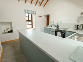 A kitchen with appliances and a counter at Tyn y Mynydd in Bull Bay
