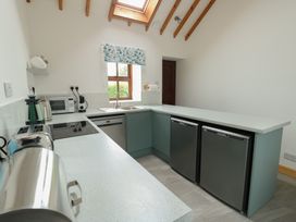 A kitchen with appliances and a sink at Tyn y Mynydd Bull Bay