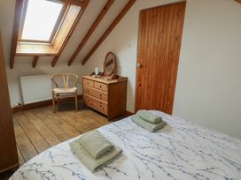 A bedroom with a bed and dresser at Tyn y Mynydd in Bull Bay